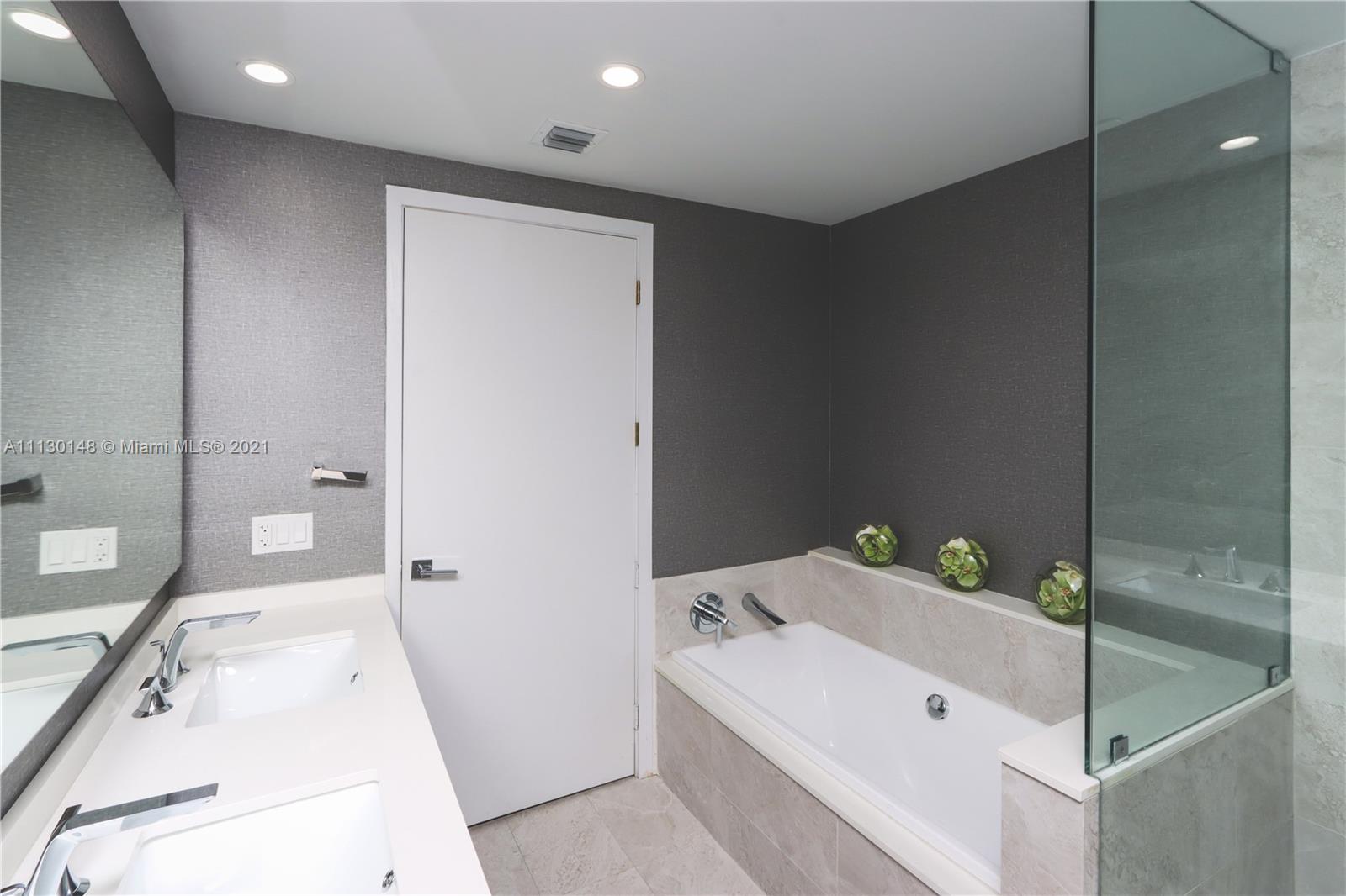 Edgewater Miami, FL 33132 - Photo 8 of 13 a bathroom with a tub sink and mirror