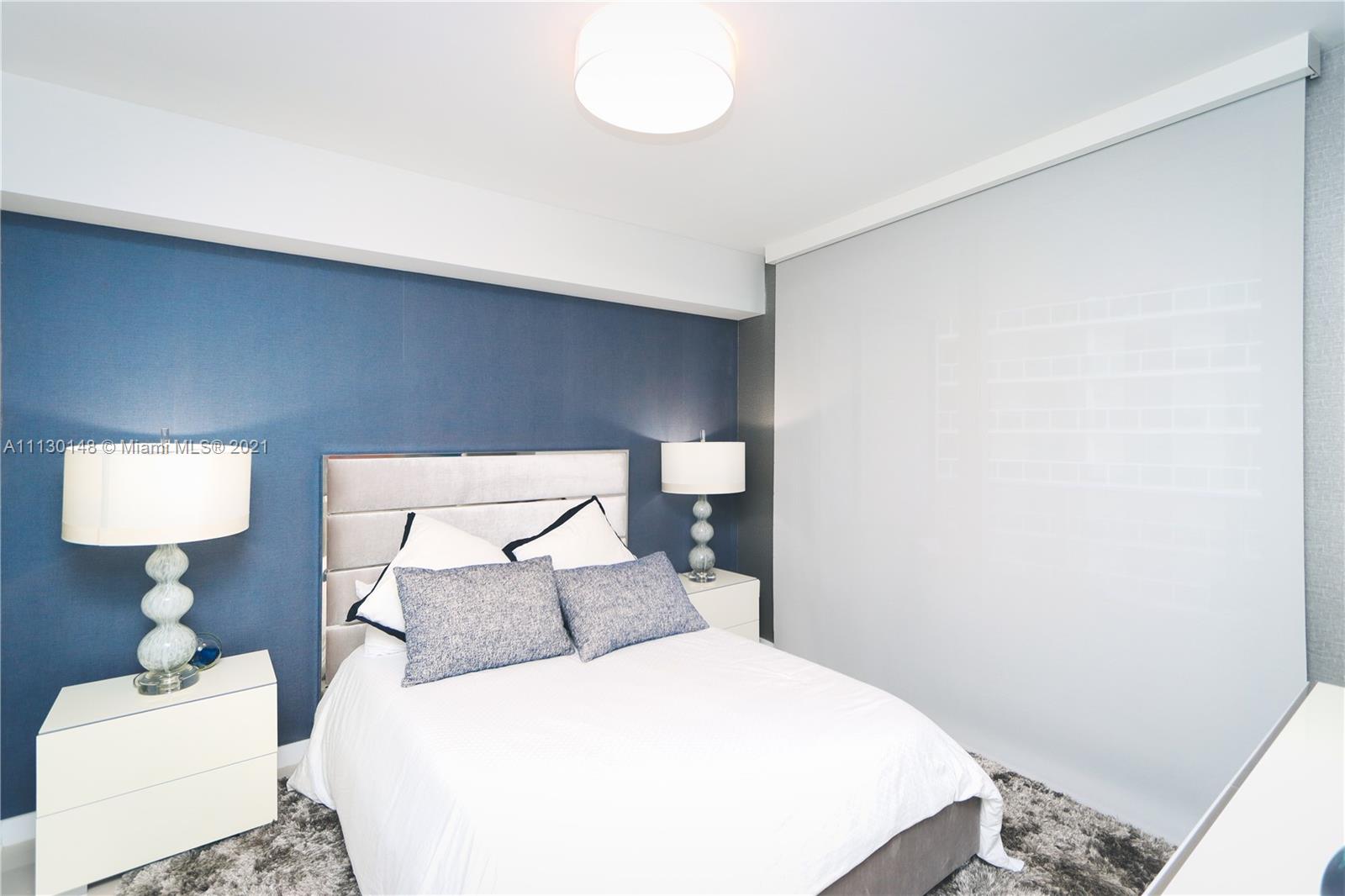 Edgewater Miami, FL 33132 - Photo 10 of 13 a bedroom with a bed and a lamp on table