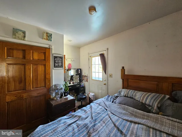 a bedroom with a bed dresser and a window