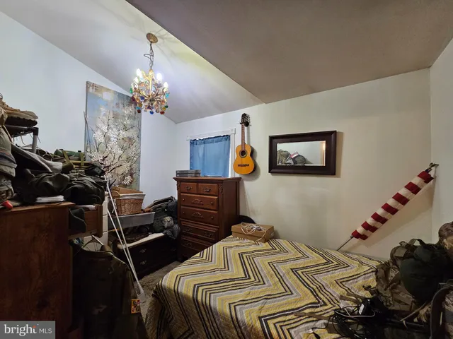 a bedroom with a bed piano and a chandelier