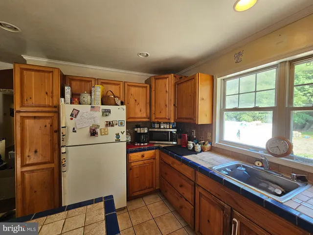 a kitchen with refrigerator a stove a sink and a counter space
