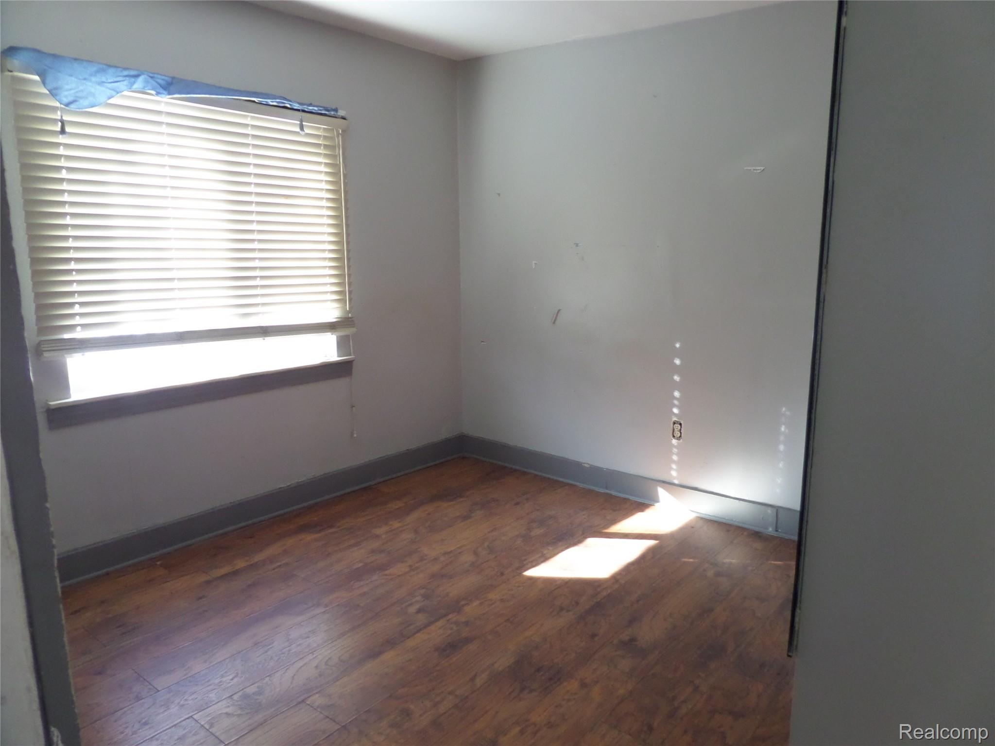 384 Perry Street Pontiac, MI 48342 - Photo 7 of 28 Unit 1 Unfurnished room featuring dark wood-style flooring and baseboards