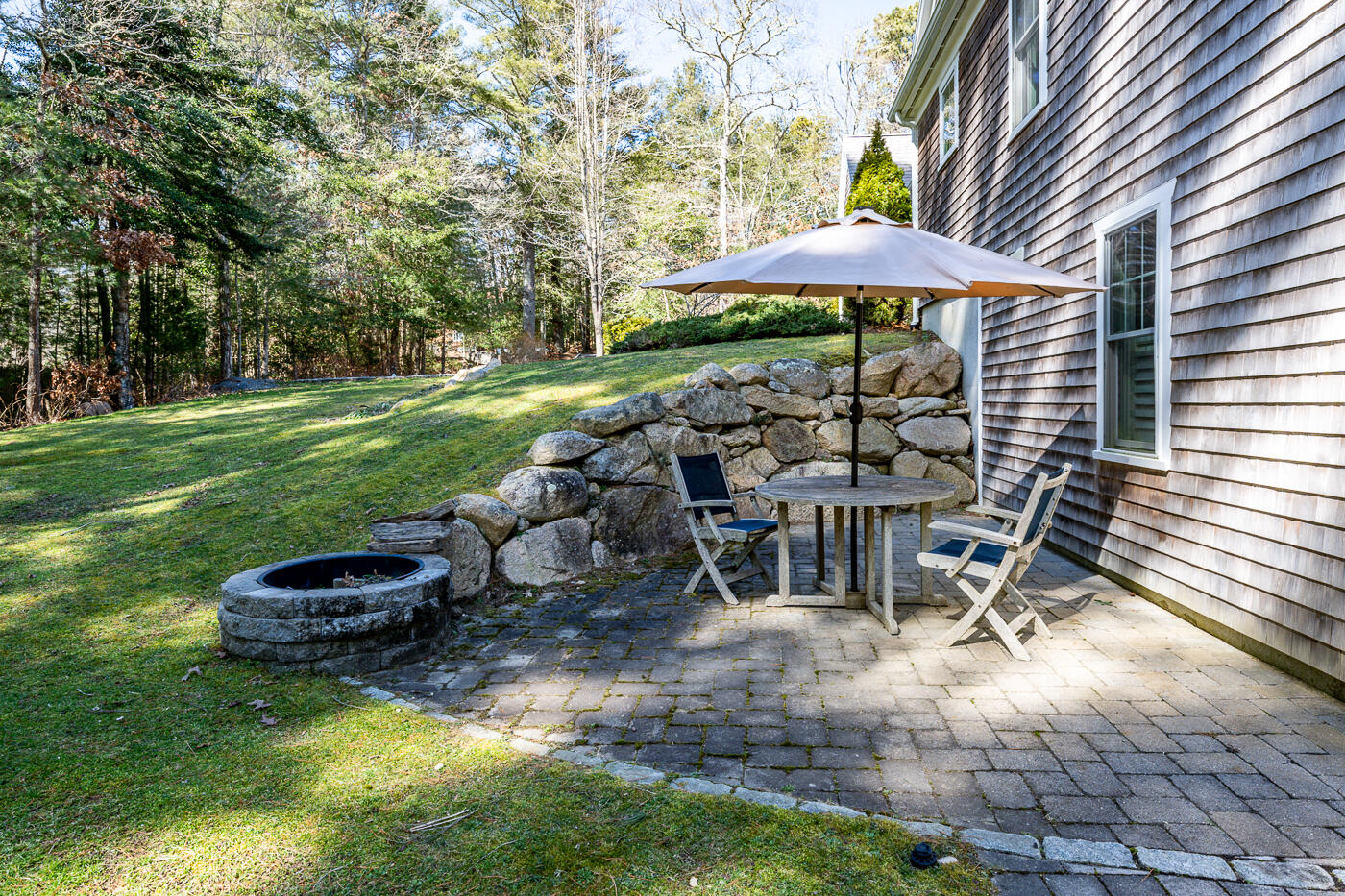 125 Woodside Road West Barnstable, MA 02668 - Photo 7 of 58 a view of a swimming pool with lawn chairs under an umbrella