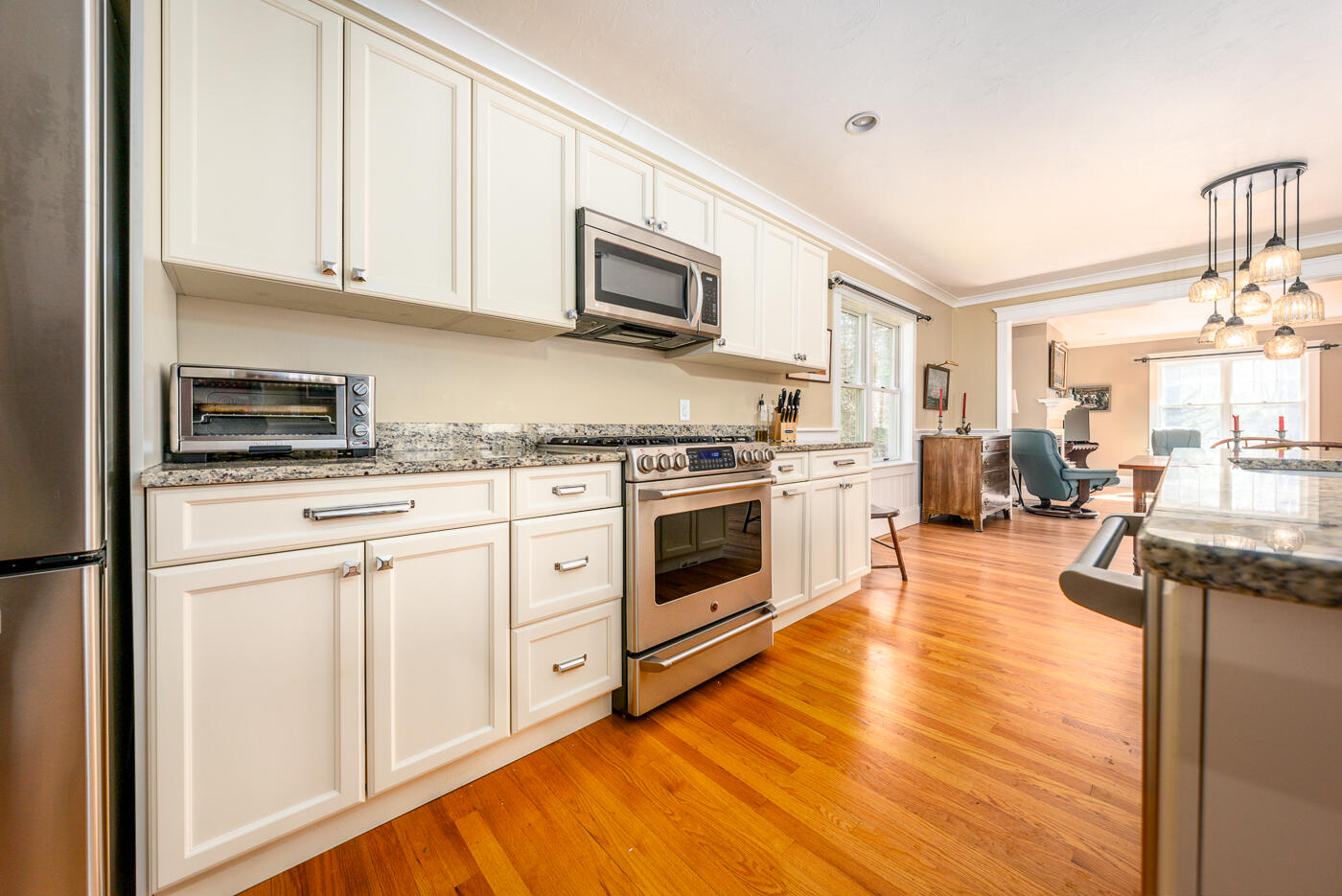 125 Woodside Road West Barnstable, MA 02668 - Photo 8 of 58 a kitchen with stainless steel appliances granite countertop a stove top oven a sink dishwasher and white cabinets with wooden floor