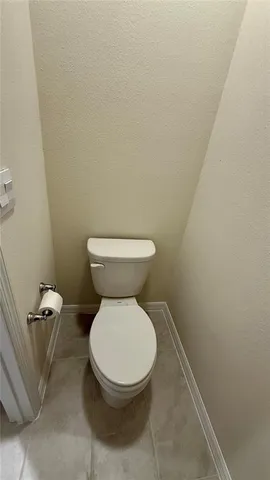 a white toilet sitting next to a white wall