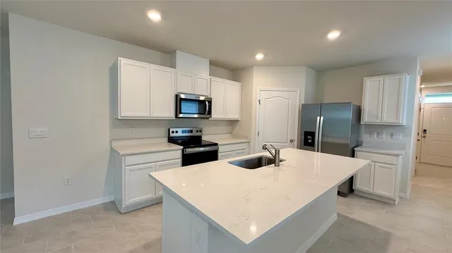 a kitchen with stainless steel appliances a refrigerator stove microwave and sink