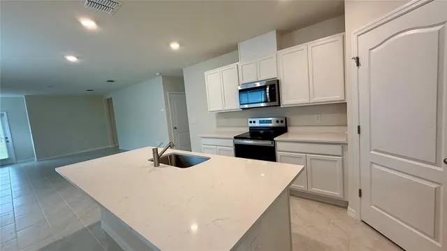 a kitchen with stainless steel appliances a stove microwave and cabinets
