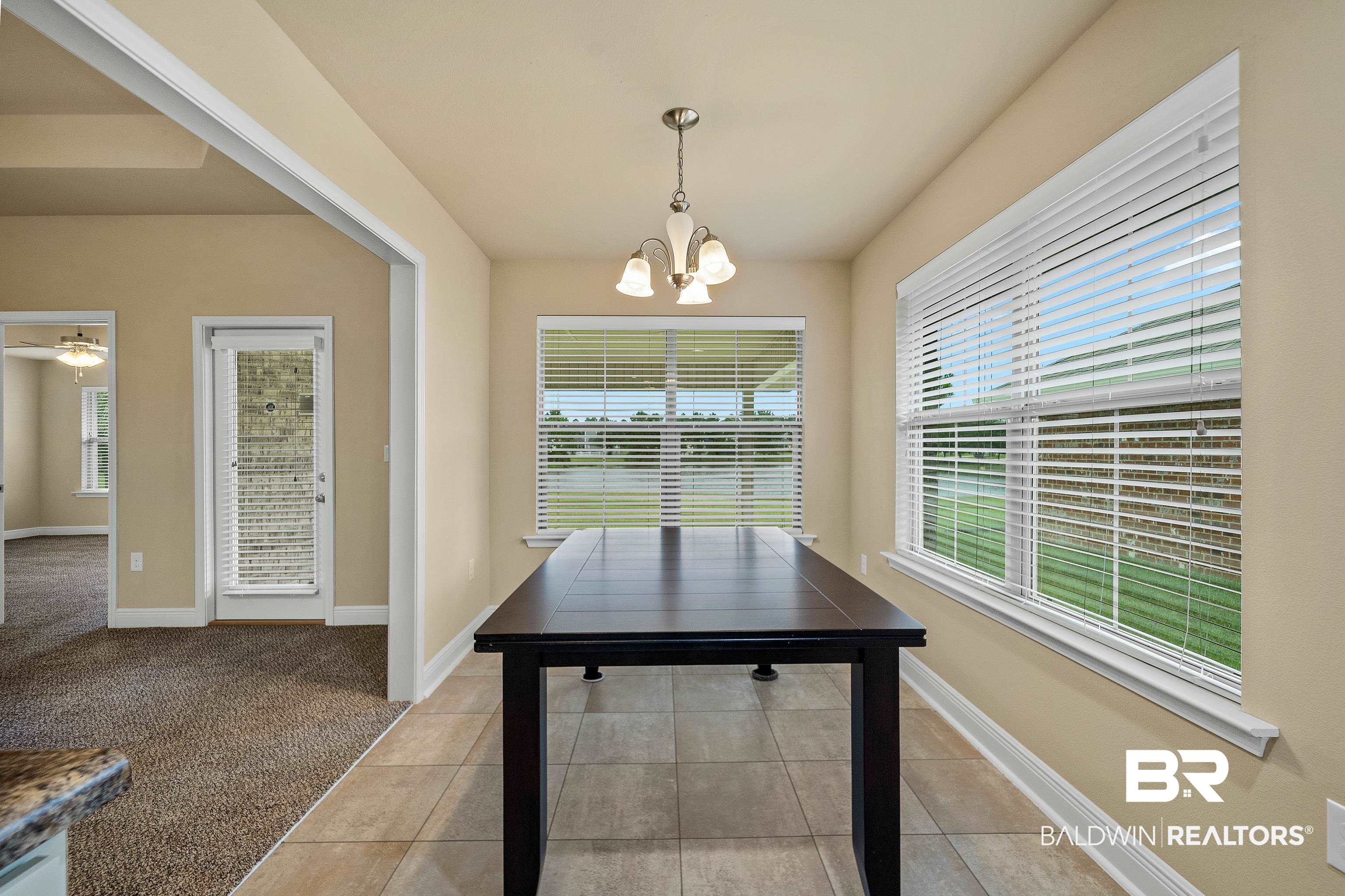 22631 Lake South Drive Foley, AL 36535 - Photo 10 of 25 Unfurnished dining area featuring light colored carpet and a notable chandelier