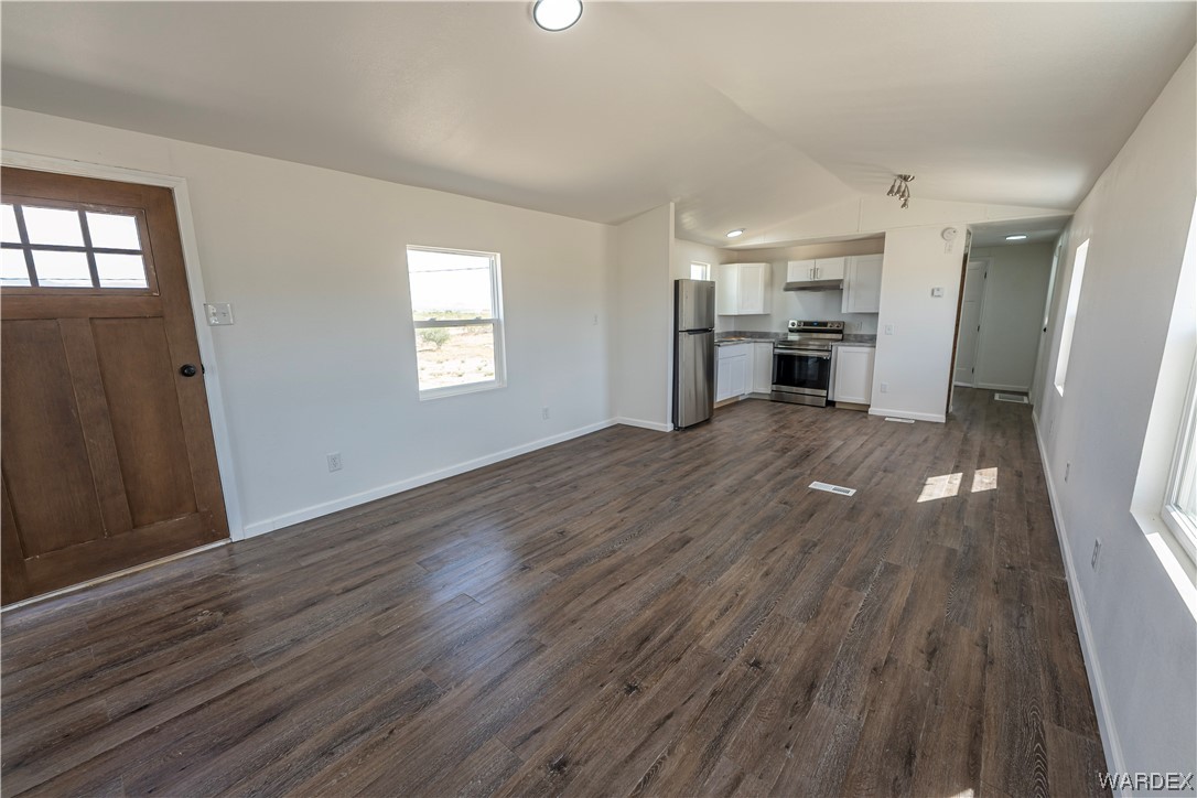 2337 South Canelo Road Golden Valley, AZ 86413 - Photo 5 of 30 an empty room with wooden floor kitchen view and windows