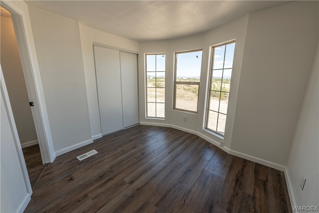 2337 South Canelo Road Golden Valley, AZ 86413 - Photo 8 of 30 a view of an empty room with wooden floor and a window