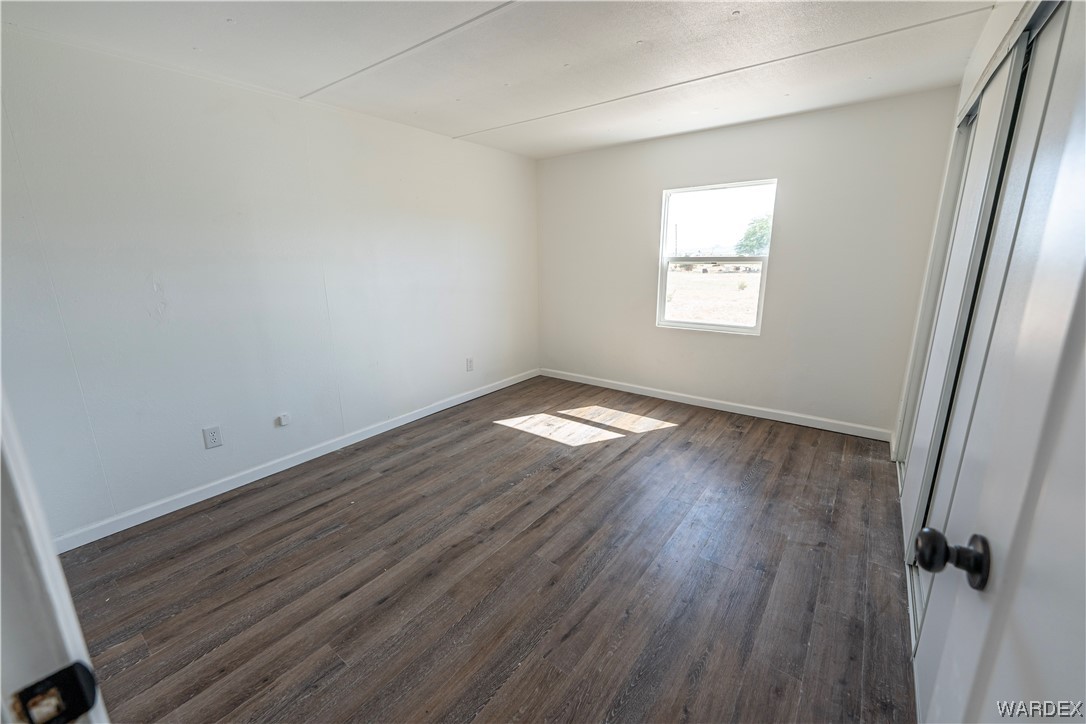 2337 South Canelo Road Golden Valley, AZ 86413 - Photo 9 of 30 an empty room with wooden floor and windows