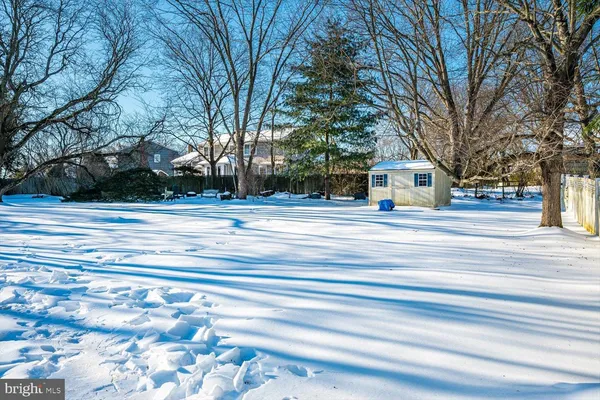 a front view of a house with a yard covered with snow