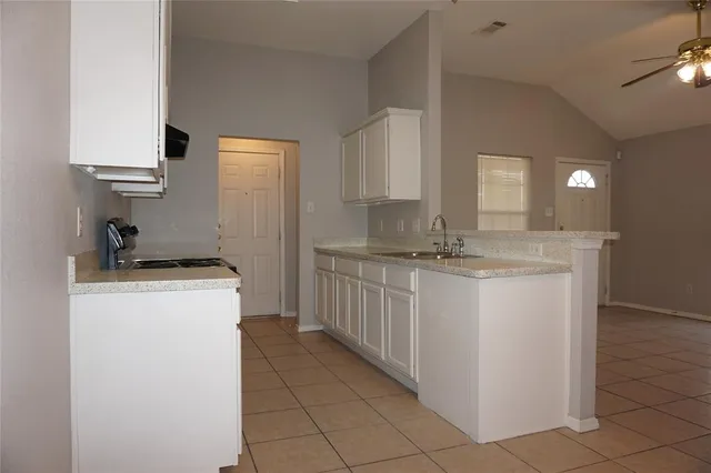 a view of a kitchen with a sink cabinet and a mirror