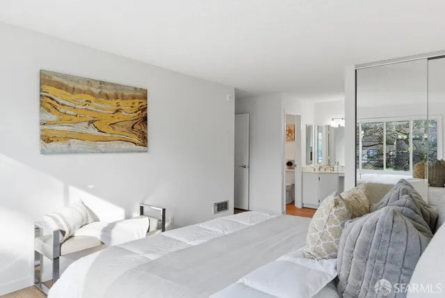 a spacious bedroom with a bed and a lamp