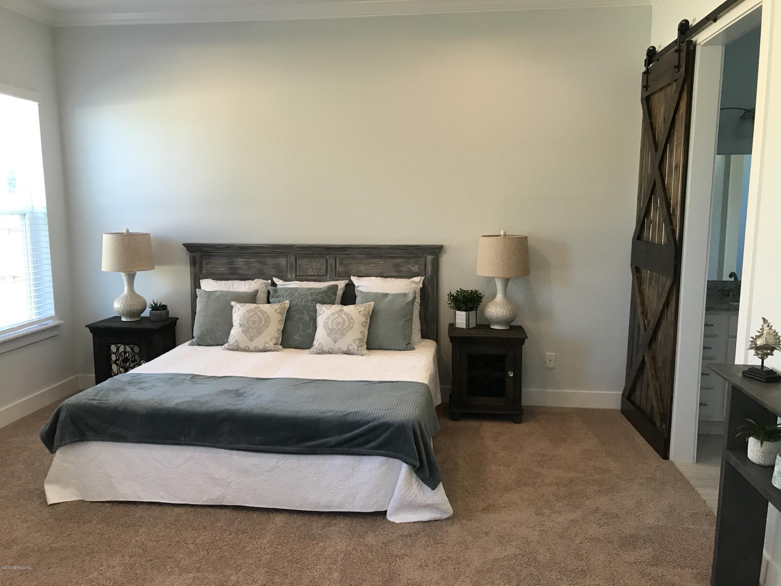 1709 Riley Street Jacksonville Beach, FL 32250 - Photo 18 of 42 a bedroom with a bed and a lamp on dresser