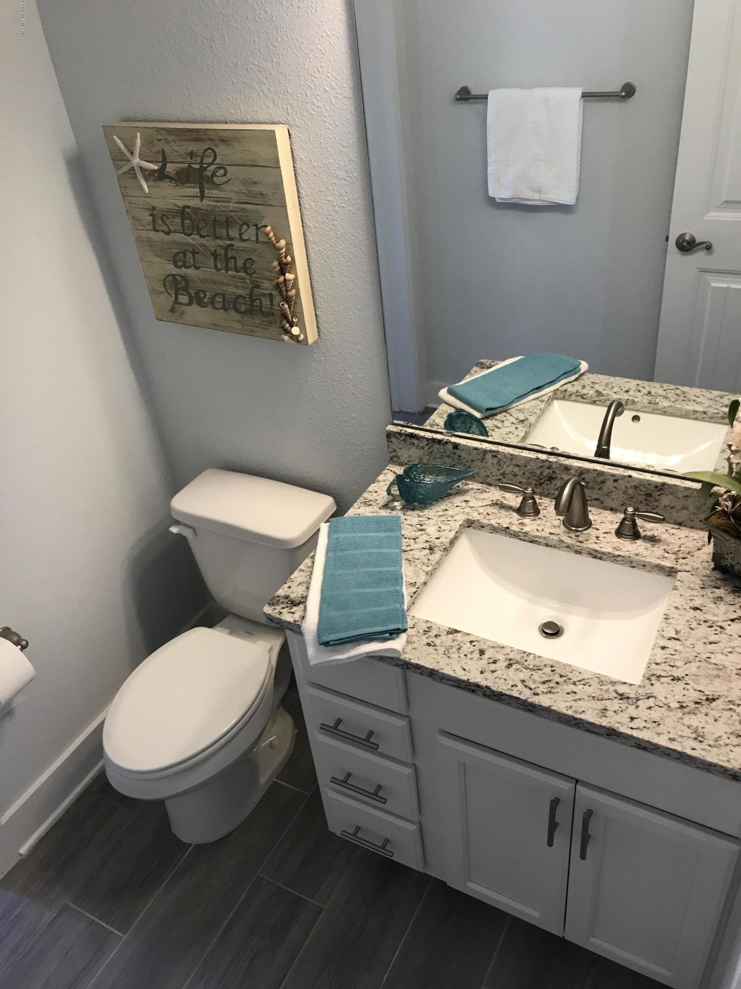 1709 Riley Street Jacksonville Beach, FL 32250 - Photo 28 of 42 a bathroom with a granite countertop toilet and a sink