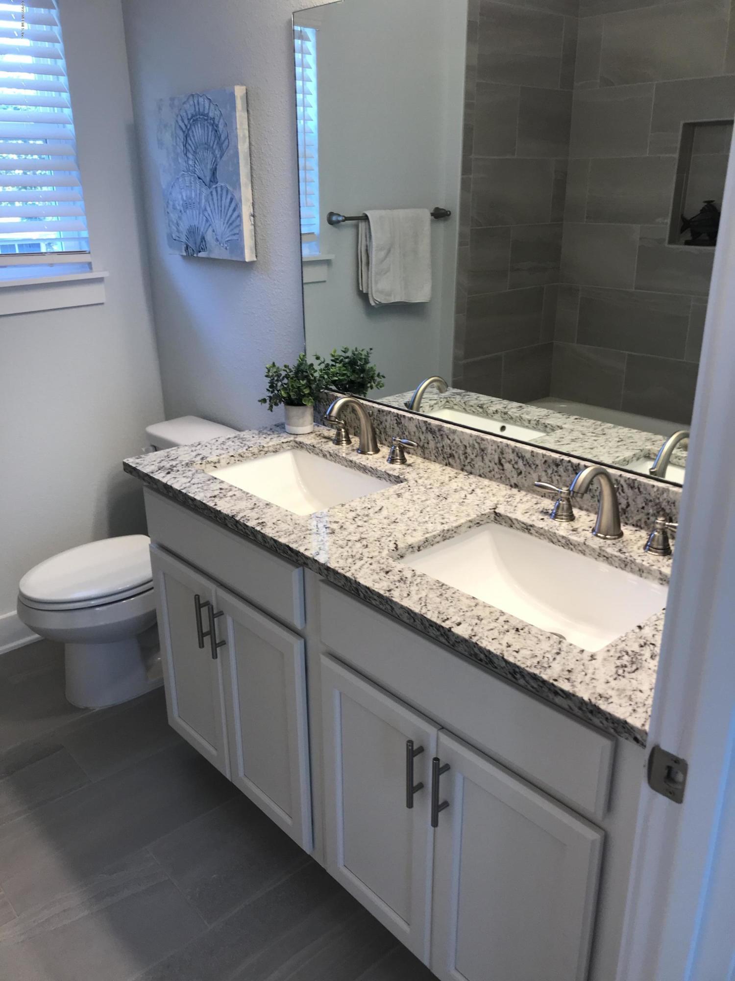 1709 Riley Street Jacksonville Beach, FL 32250 - Photo 36 of 42 a bathroom with a granite countertop sink a toilet and a mirror