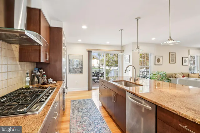 a large kitchen with stainless steel appliances kitchen island a large counter top a sink a stove and a refrigerator