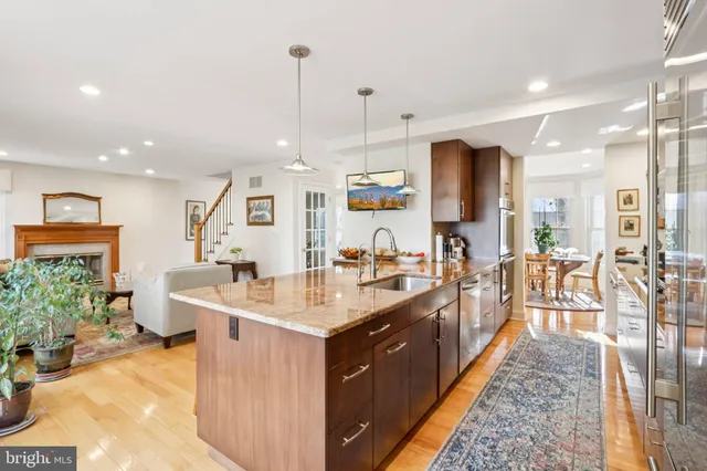 a kitchen with kitchen island granite countertop a sink counter top space appliances and cabinets