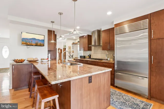 a large kitchen with kitchen island a large counter top space a sink stainless steel appliances and cabinets