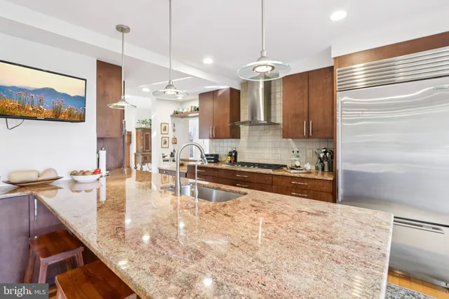 a kitchen with stainless steel appliances granite countertop a stove a sink and a white cabinets