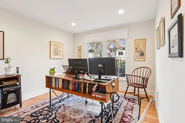 a spacious bedroom with a bed and a flat tv screen on dresser