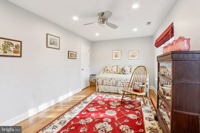 a living room with furniture a rug and a bookshelf