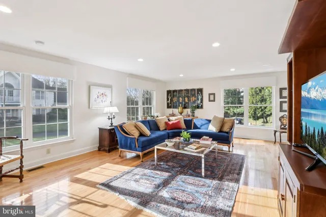 a living room with furniture kitchen view and a large window