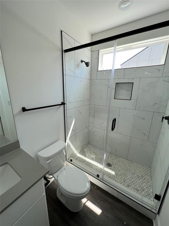 7603 Carver Avenue, Unit 2 Austin, TX 78752 - Photo 5 of 9 Marble-patterned wall tile and a sleek glass enclosure highlight the modern walk-in shower.