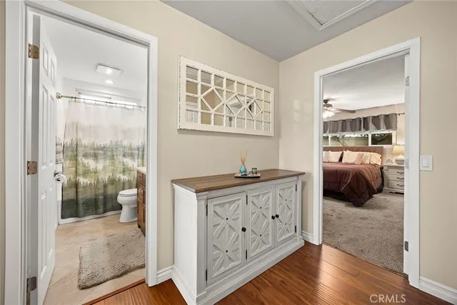 a en suite bathroom with a granite countertop sink a toilet a glass door shower and a mirror