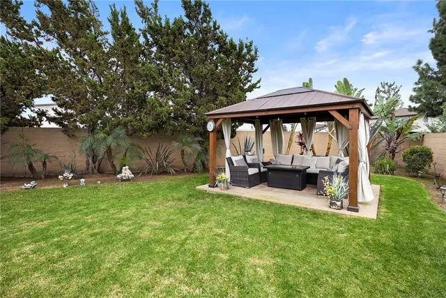 a view of a chair and table in backyard of the house