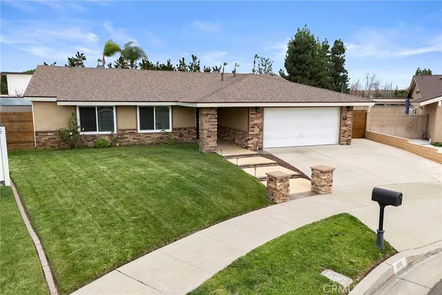 a front view of a house with a garden and plants
