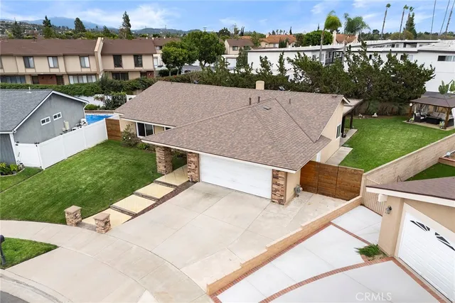an aerial view of a house with a garden and houses