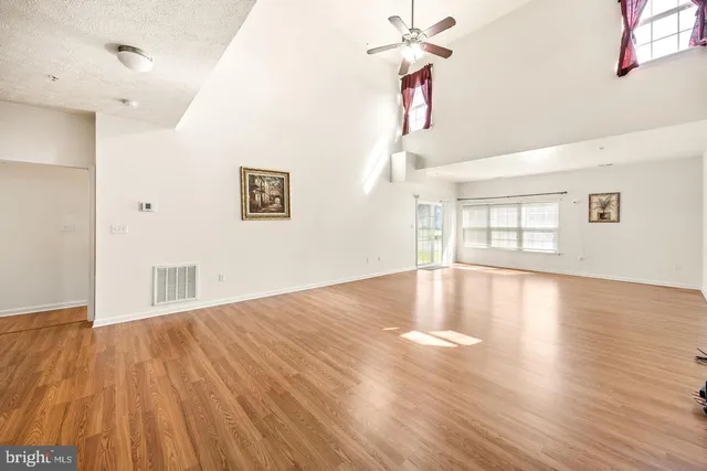 a view of a living room a dining room with wooden floor and a large window