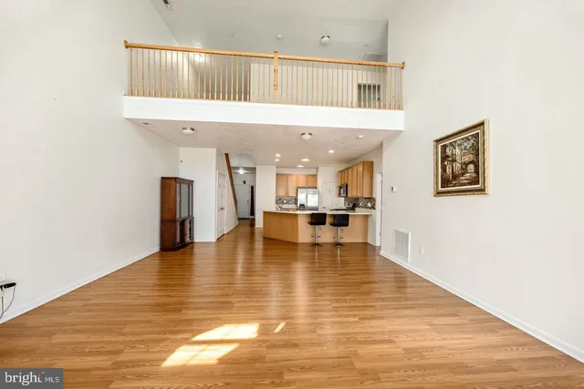 a kitchen with stainless steel appliances granite countertop a sink a stove a refrigerator cabinets and wooden floor