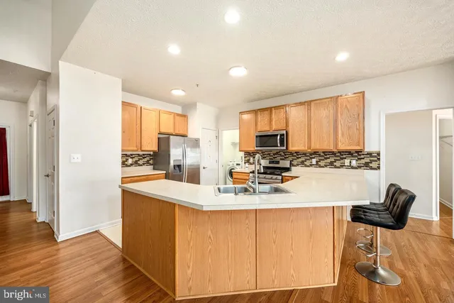 a kitchen with stainless steel appliances granite countertop a refrigerator and a stove