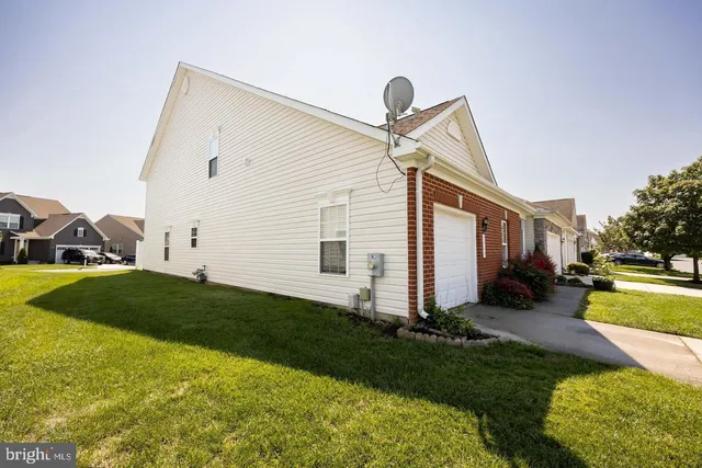 a view of a house with a yard and a large tree