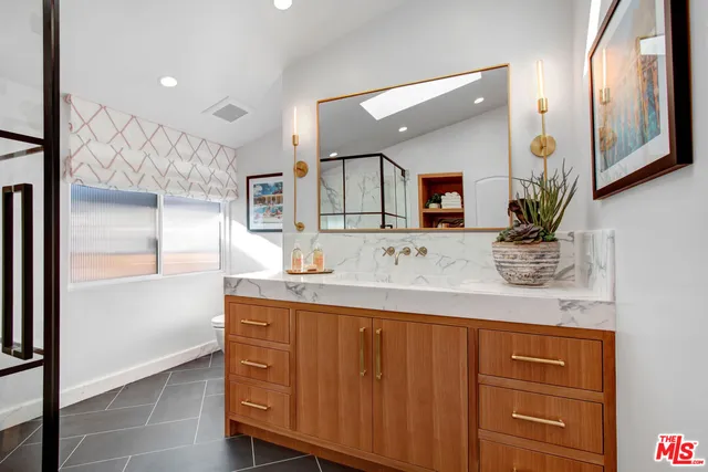 a bathroom with a granite countertop sink a mirror and a