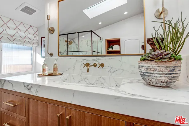 a view of bathroom with a sink a mirror and a window