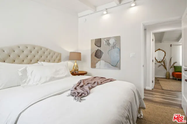 a bedroom with a large bed and a chandelier