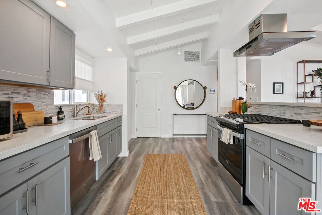 6440 Rhea Avenue Reseda, CA 91335 - Photo 5 of 22 a kitchen with cabinets stainless steel appliances a sink and a stove