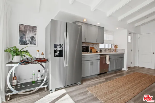 a kitchen with white cabinets and appliances