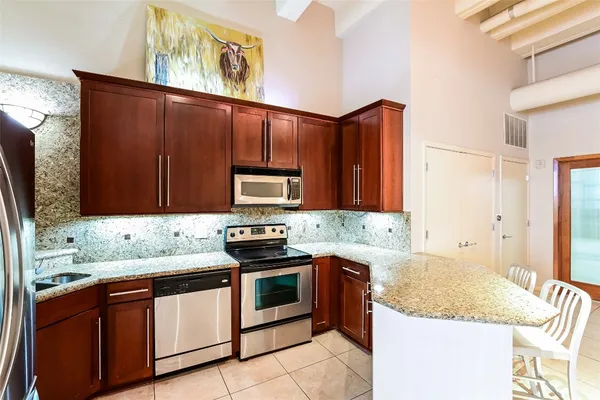 a kitchen with stainless steel appliances granite countertop a sink stove and microwave