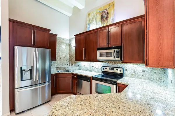 a kitchen with stainless steel appliances granite countertop a refrigerator stove and oven