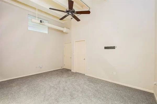 an empty room with a ceiling fan and wooden floor