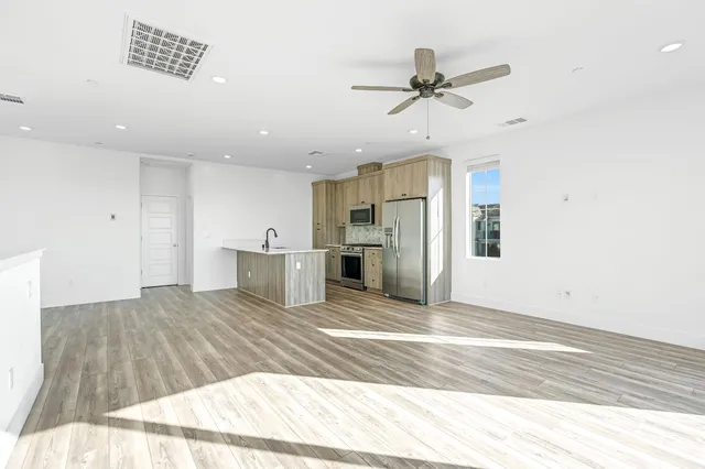 a view of a kitchen with wooden floor and a ceiling fan