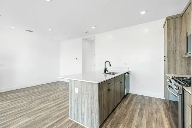 a kitchen with stainless steel appliances granite countertop a sink stove and cabinets