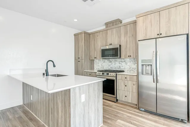 a kitchen with kitchen island a sink stainless steel appliances and cabinets
