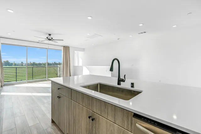 a kitchen with a sink and wooden floor