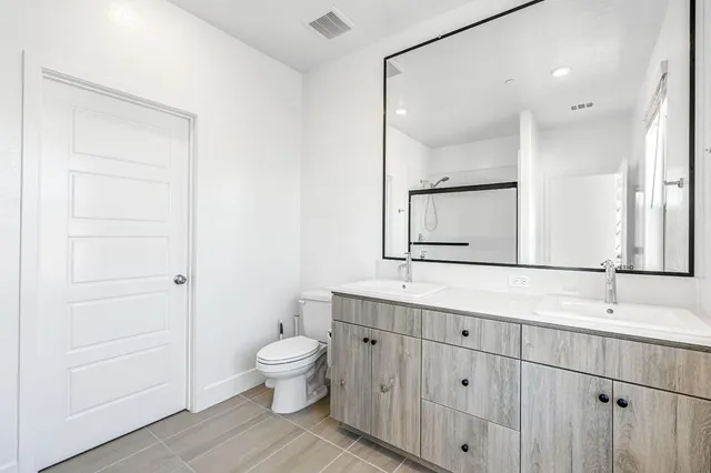 a bathroom with a toilet a sink and a large mirror